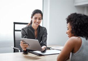 two women looking at a tablet together