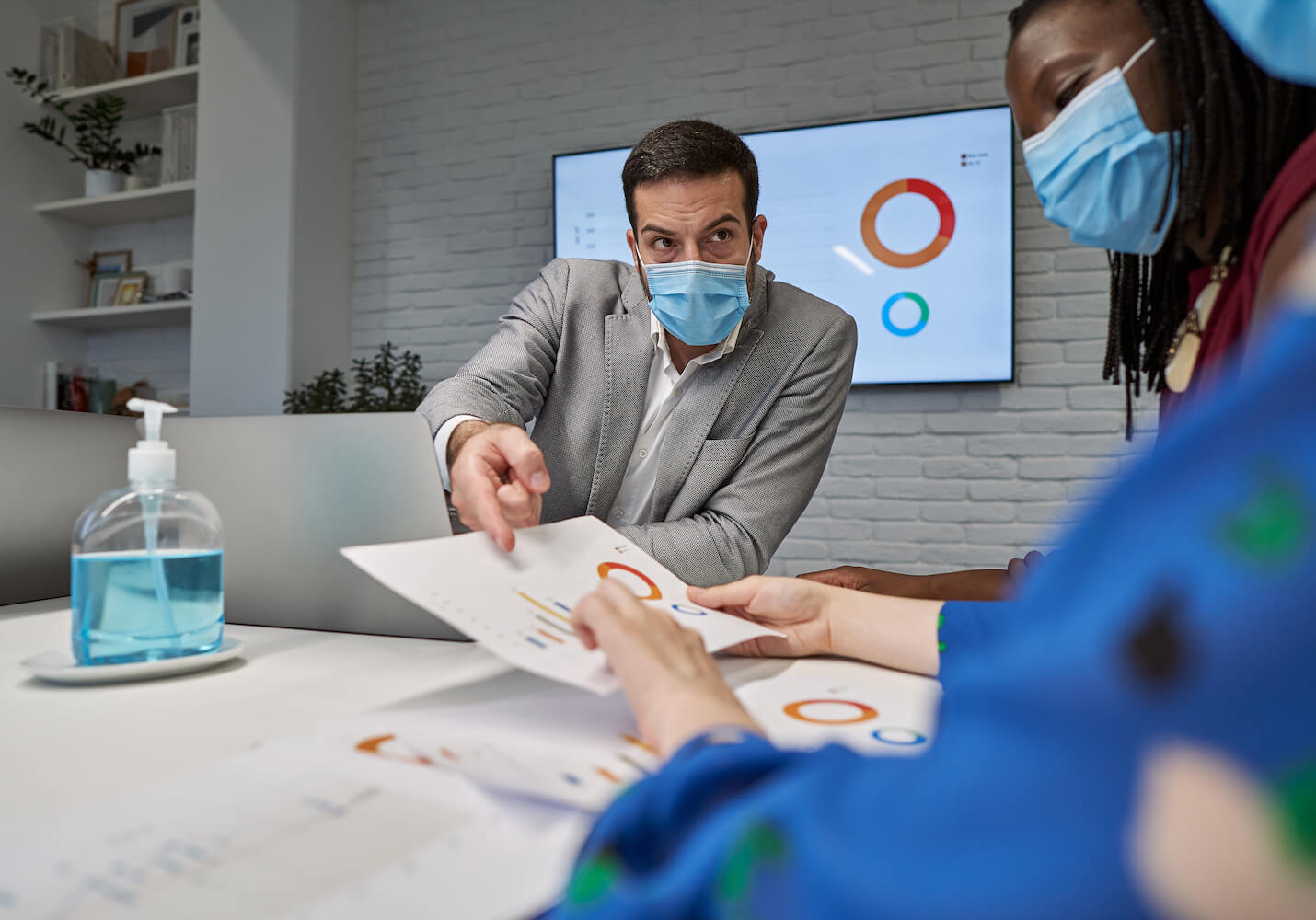 Man and woman wearing masks in meeting