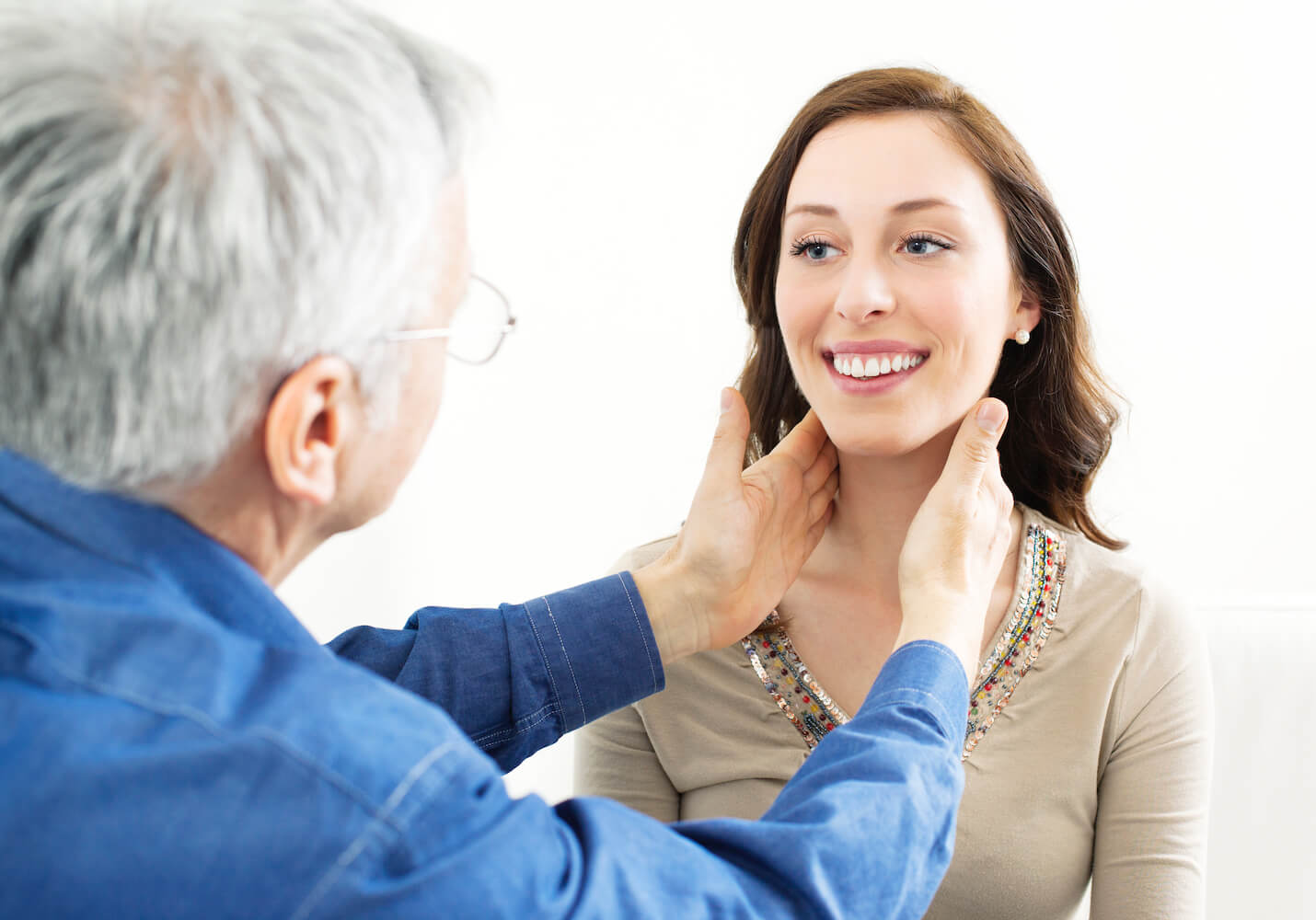 Doctor examining patient's thyroid