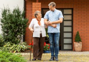 Man assisting elderly woman