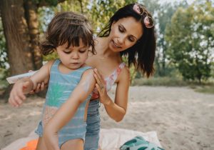 Mother applying sunscreen to child