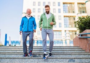 Older man and younger man exercising on stairs