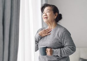 Senior woman nursing sore throat