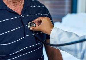 Doctor using stethoscope on patient