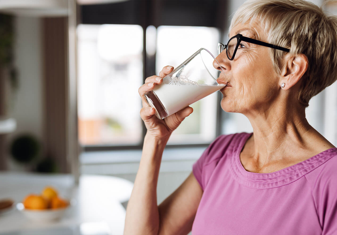 Senior woman drinking a glass of milk